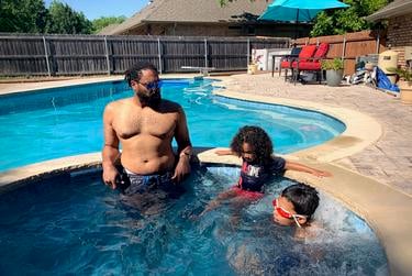 From left, Joseph Norman relaxes in the pool at his in-laws' house in Granbury with his sons Joseph and Maxwell.