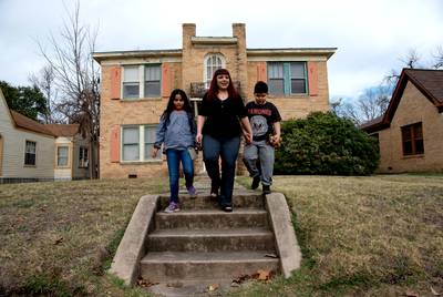 Melissa Romo and her children Mia and Zavier in front of their home on San Antonio's West Side.