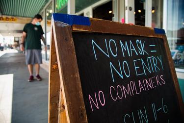 A sign outside of a South Austin store asked customers to follow COVID-19 precautions on March 3, 2021.