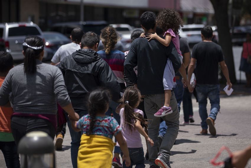 A group of migrants is ushered by volunteers to the Catholic Charities Humanitarian Respite Center across the street from the bus station in McAllen on June 25, 2019.