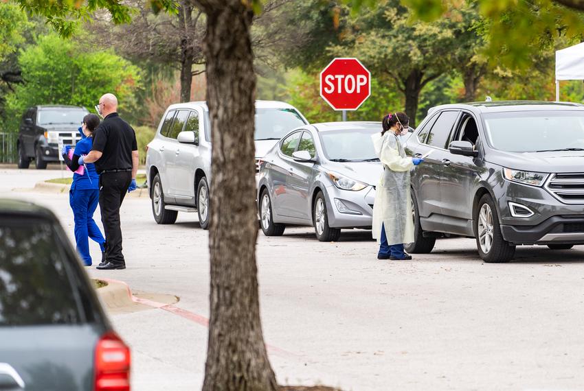 A doctor wearing protective clothing administers a test to patient at a drive-thru Covid19 testing facility at Baylor, Sco...