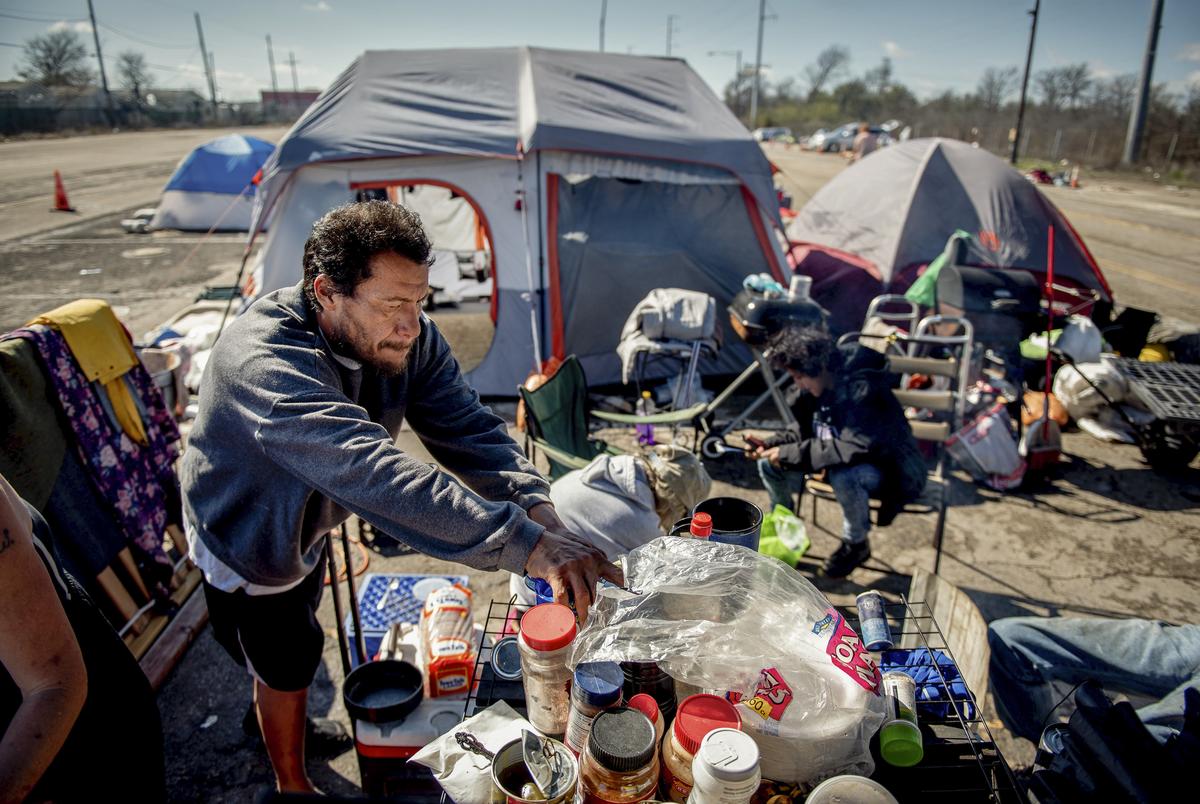 Manuel Baez helped prepare a meal at the state-sanctioned camping site in Austin in January. 