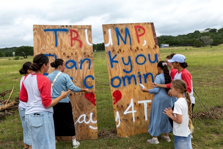 Volunteers who help locals clean the debris from their houses, place a banner on a main road ahead of U.S. President Donald Trump's travel to Texas to tour areas affected by deadly flash flooding, in Hunt, Texas, U.S., July 11, 2025. REUTERS/Umit Bektas     TPX IMAGES OF THE DAY
