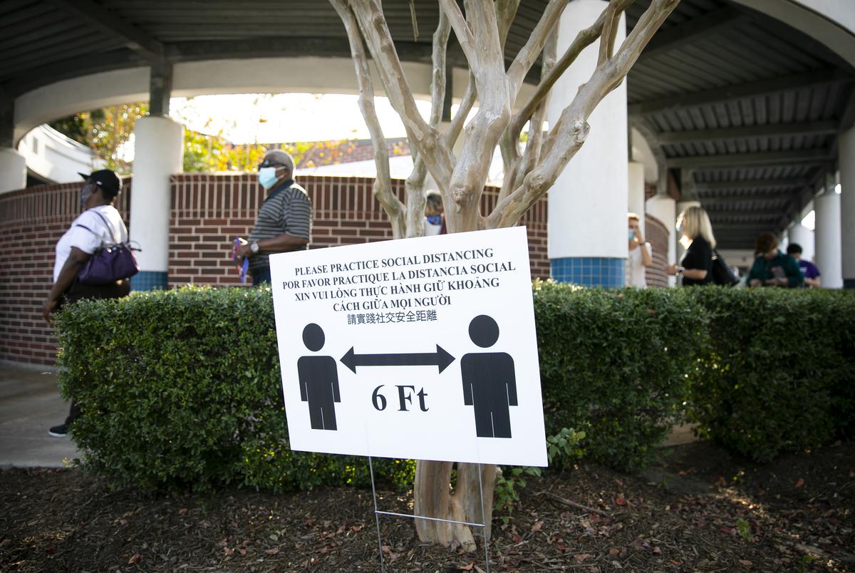 Voters wrap around the front of the Bayland Community Center before entering to cast their ballots during the first day of early voting in Houston on Oct. 13, 2020.