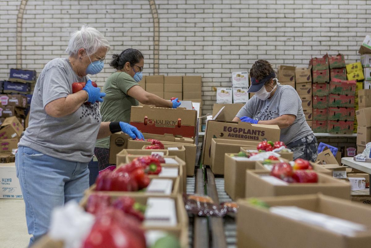 Volunteers Christy Minjarez, Sandy Grace and Yvonne Mendoza prepare boxes of food at the Kelly Memorial Food Pantry in Central El Paso, which serves 700-1000 families a day during the Coronavirus pandemic. April 7, 2020. 