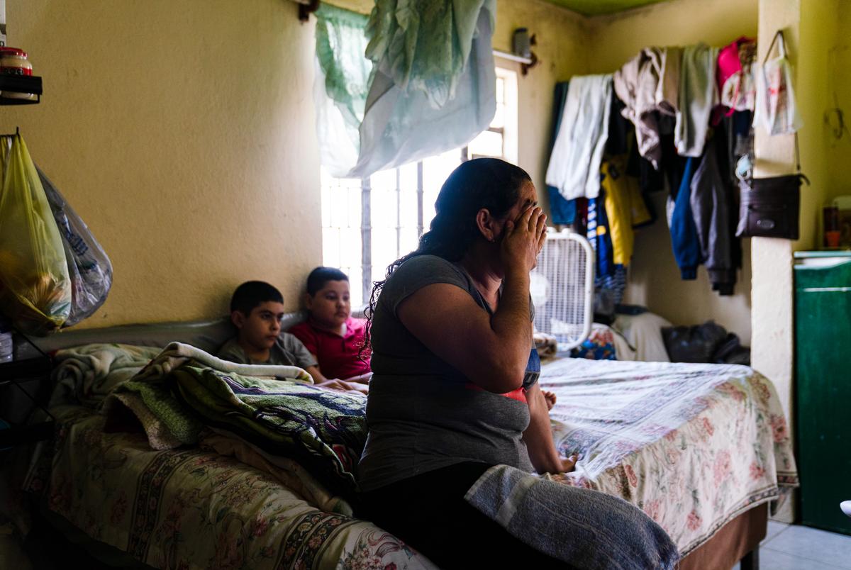 Marlen D. Cruz, 42, an asylum seeker from Honduras, cries as she shares her story of why she left her country in a bedroom that a friend who is also an asylum seeker shares with her in Matamoros, Mexico on Feb. 26, 2021.