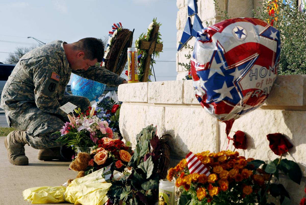 United States Army Specialist Robert Orcutt prays near a makeshift memorial for victims of the shootings at Fort Hood Army post in Fort Hood, Texas November 9, 2009. The death toll from an Army psychiatrist who opened fire at the Fort Hood Army post rose to 13 on Friday, and Army officials said the suspected shooter was hospitalized and on a ventilator. U.S. intelligence agencies learned an Army psychiatrist tried to contact people linked to al Qaeda and they gave the information to federal authorities before the man allegedly went on shooting spree in Texas last week, U.S. sources said on Monday.   REUTERS/Jessica Rinaldi (UNITED STATES MILITARY CRIME LAW CONFLICT IMAGES OF THE DAY)