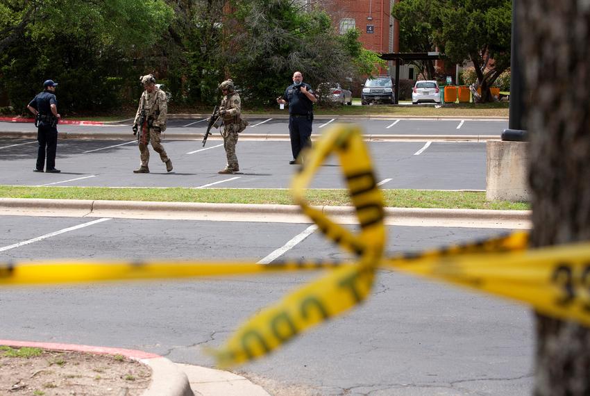 Law enforcement personnel investigate the scene of a deadly shooting at an apartment complex in Austin on April 18, 2021.  Stephen Broderick, a former sheriff's office detective, is accused of shooting his ex-wife and two other people.