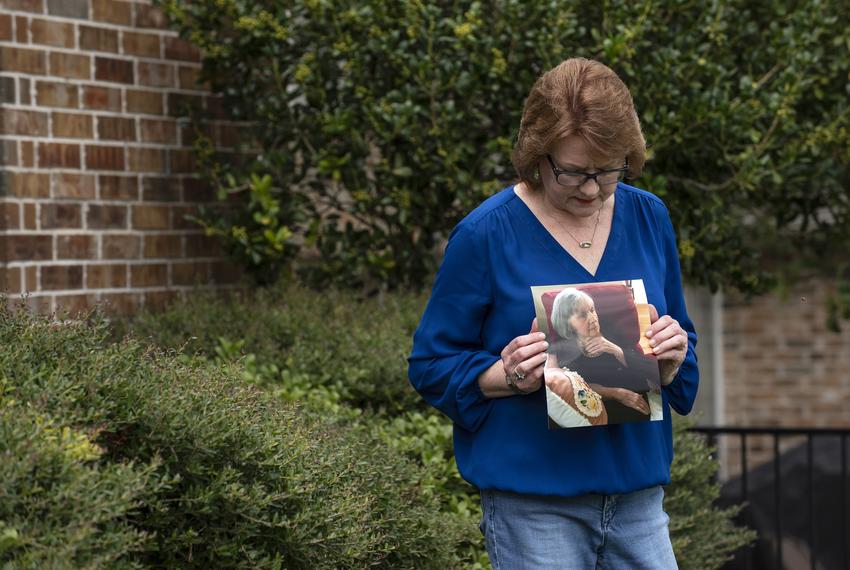 Genny Lutzel holds a photograph of her mother, Paula Spangler, 80, outside her home in Rockwall on Aug. 06, 2020. Lutzel hasn't seen her mother, who lives in a nursing home and suffers from Alzheimer's, since March due to COVID-19.