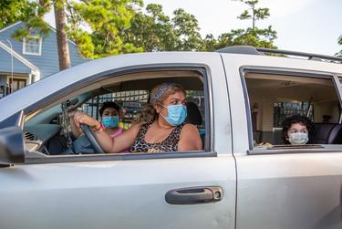 Maria Linares and her children receive desks and supplies during the Drive-Thru Student School Supply Giveaway at Raul Yzaguirre Schools for Success in Houston on Aug. 22, 2020.