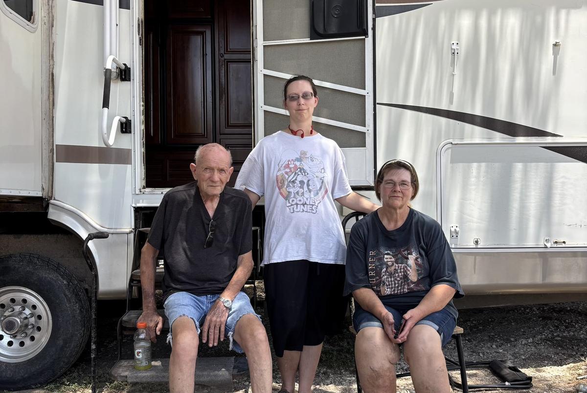 Army veteran Harry Sherwood sits with his step-daughter Tammy Roe and granddaughter Tamera Garcia outside a camper provided by Veterans First at his home in Sandy Creek. He settled there about 35 years ago, and moved to higher ground in 2003 after his mobile home flooded. He figured he was safe, but the flood took almost all he had. “Looking at it now, you’d never be able to tell how beautiful it used to be out here,” Tamera said.