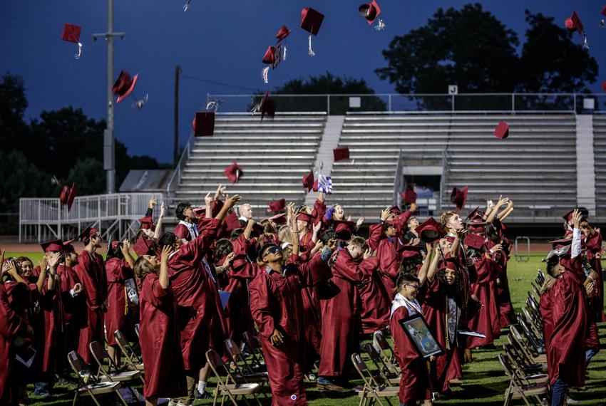 Graduates throw their caps into the air in celebration at the Uvalde High School graduation ceremony on June 24, 2022.