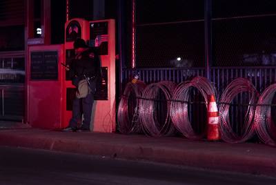A U.S. border patrol agent stands at the limit of the U.S. and Mexico border in Eagle Pass. Concertina wire can be seen to the left of the officer. Feb. 8, 2019.