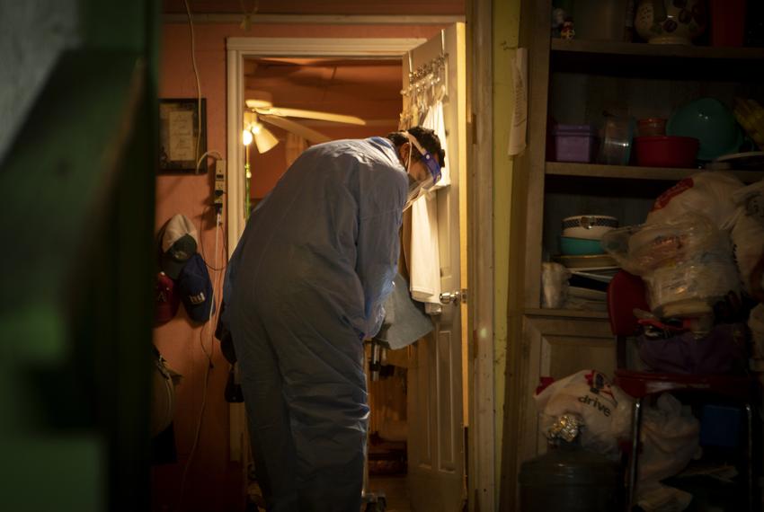 Juan Lopez removes a dead body from a home in McAllen. July 17, 2020.