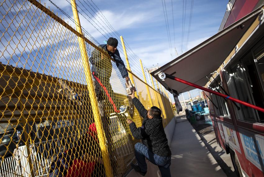 A young migrants reaches for food and coffee from a shelter employee in Piedras Negras. Feb. 18, 2019. 

