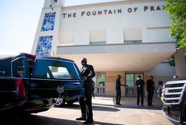 A man closes the back door of a hearse in preparation for George Floyd's public memorial service at the Fountain of Praise Church in Houston.