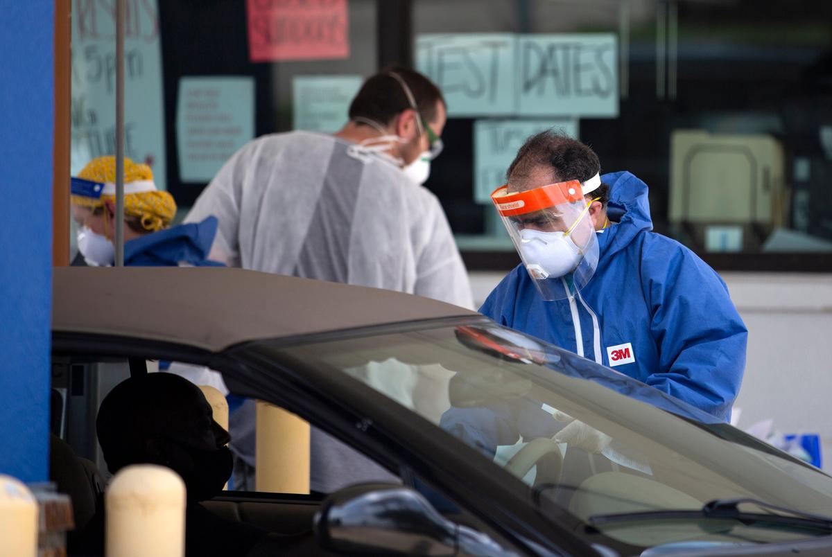 A health care worker speaks to a patient at a drive-thru testing site at Exceptional Medical Plaza in Garland on June 30, 2020.