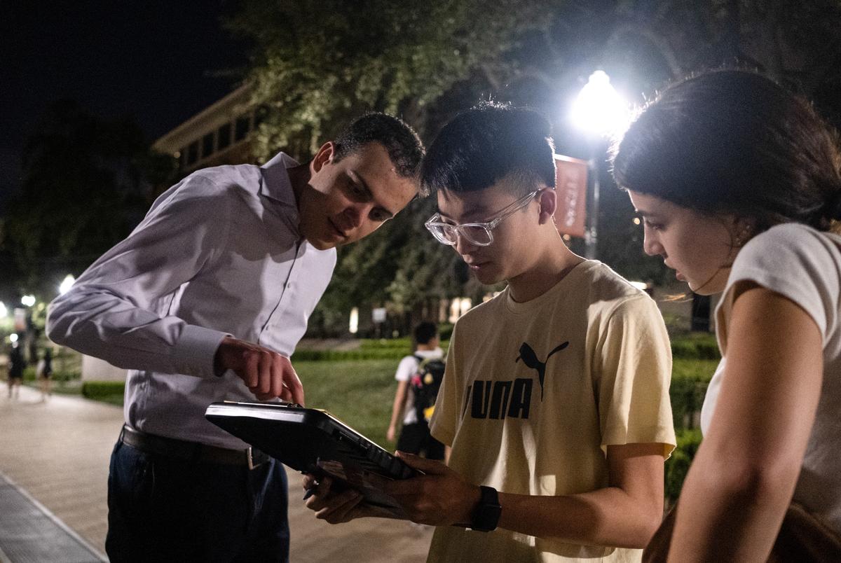 Alex Pham, an Asian American student at UT, registers to vote, as University Democrats vice president Emma Reed, right, and volunteer deputy registrar Alex Meed, left, help. Scenes from a drive to register voters held by University Democrats on the University of Texas campus in the final hours of voter registration for midterm elections on Tuesday, Oct 11, 2022 in Austin. Asian communities are growing rapidly in Texas but they are still feeling left out of the political process . (May-Ying Lam for The Texas Tribune)