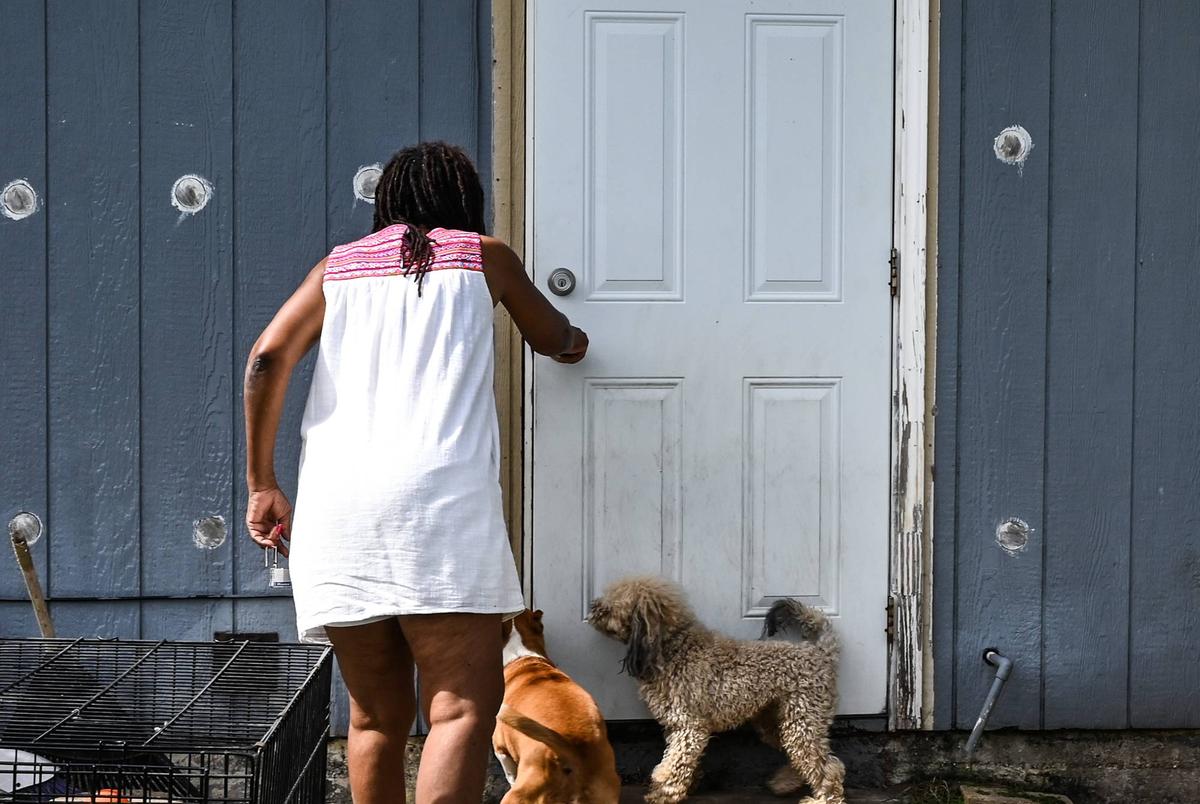 Dana Jones, who has been a victim of many floods, lets her dogs inside her home in Houston on August 1, 2022.