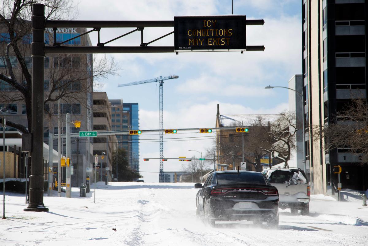 Vehicles attempt to drive uphill through snow and ice on Guadalupe street in Austin, Feb. 15, 2021.