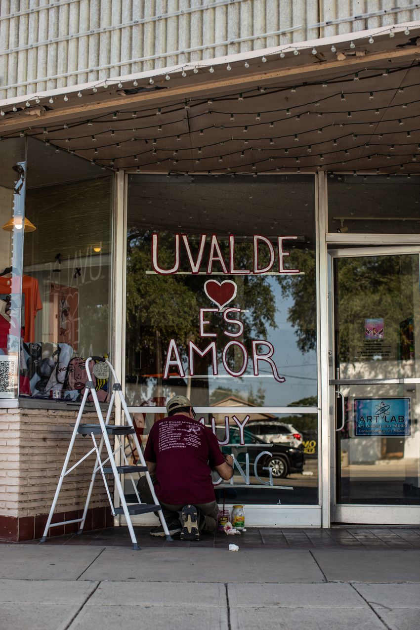 Avel Ortiz, 55, puts the final touches on a window message in front of his business in Ulvade on May 29, 2022. Ortiz said he plans to work with several Texas artists to create murals of all 21 victims across town.