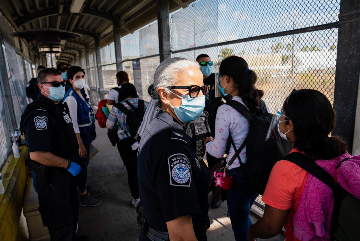 Asylum seekers wearing face shields make their way to be processed in the U.S. at the Gateway International Bridge in Matamoros, Mexico on Feb. 26, 2021. Some of them had been living at the migrant camp for nearly two years after being sent back to Mexico under the Migrant Protection Protocols, MPP, to wait for their cases to be decided in the U.S.