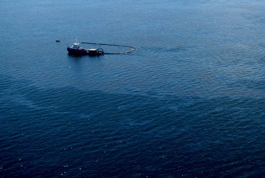 Response boats work to clean up oil where the Deepwater Horizon offshore oil rig sank on April 22, 2010.