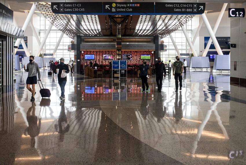 Travelers walk through Terminal C of IAH George Bush Intercontinental Airport during the COVID-19 outbreak in Houston on July 21, 2020.