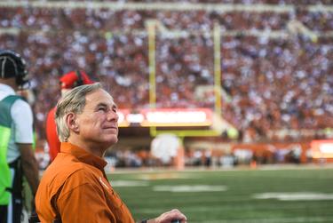 Gov. Greg Abbott watches on the sidelines Texas' game against Louisiana State on Sept. 7, 2019 in Austin.