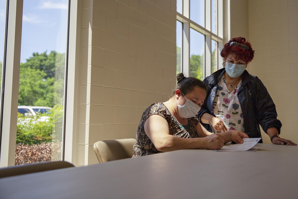 Onelia Orellana is assisted by Texas Department of State Health Services Specialist and Translator Maria Palacio as she fills out the forms needed to receive a COVID-19 vaccine at the Tennison Memorial United Methodist Church in Mt. Pleasant on May 7, 2021.
