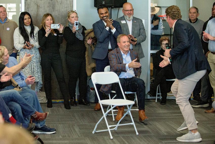 Texas Attorney General Ken Paxton gets up to shake the hand of Tarrant County GOP Chairman Bo French during a rally at the Tarrant County Republican Party Headquarters in Fort Worth on Jan. 6, 2025. Standing behind Paxton, hands together, is Abraham George, chairman of the Republican Party of Texas.