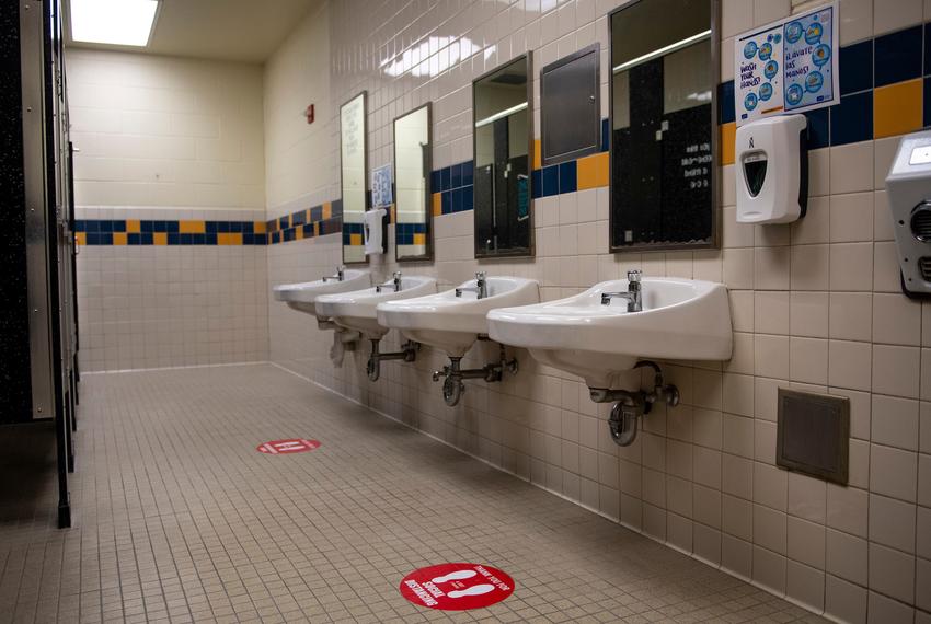 Social distancing decals are posted in front of the sinks to be used in a boys restroom at Ott Elementary School on Tuesday, Aug. 11, 2020 in San Antonio. The school plans to turn off the water for the sinks and urinals not in use to maintain social distancing between students in the restroom.