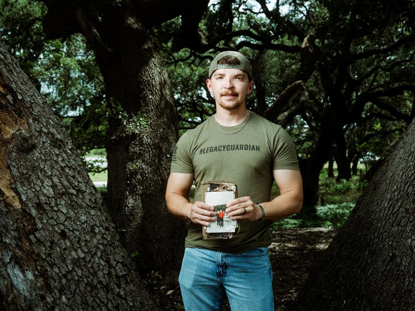 Michael Guyer holds photos and patches from the Heart of the Hills camp that he has found while volunteering in search efforts in the aftermath of the flood in Kerr County.