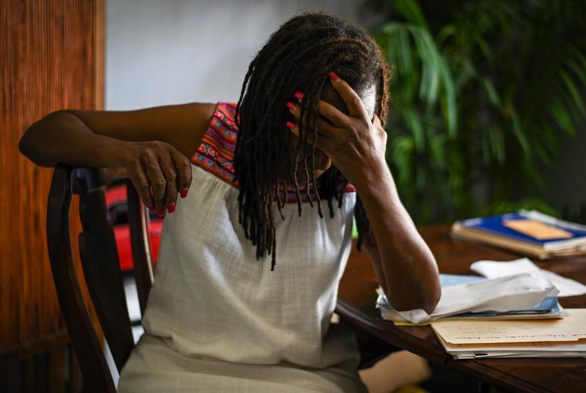 Dana Jones, who has been a victim of many floods, holds her head in her hand as she recounts her experiences at her home in Houston on August 1, 2022.