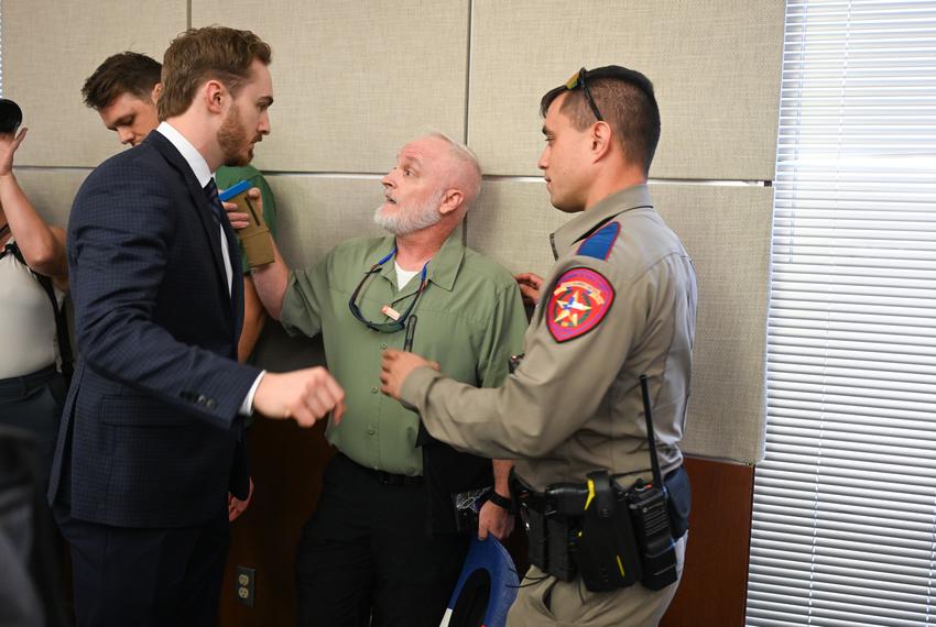 House Sergeant-At-Arms, l, and Texas DPS argue with a witness who was later removed from the hearing for rowdyness against HB 8 in THe House State Affairs Committee meeting on August 22, 2025.