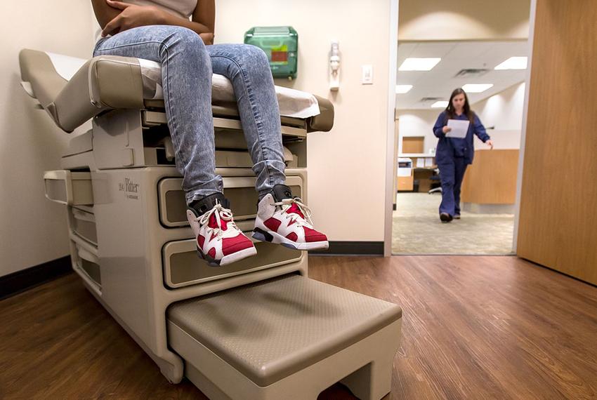 Eighth-grader Montanique DeShay waits as Ashlyn Brooks, medical assistant at MedSpring Urgent Care in Austin, comes to check on her on Wednesday.