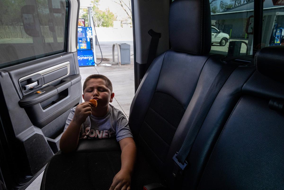 Austin Treviño blows on a chip during a stop at a convenience store.