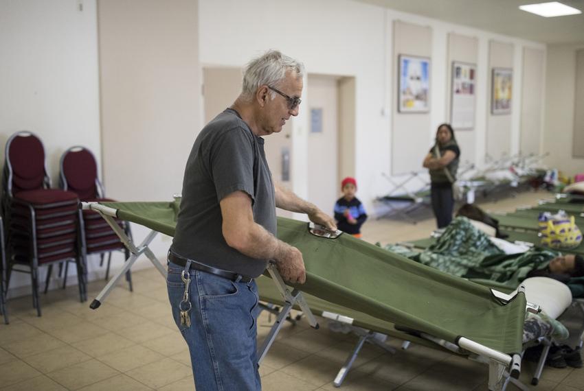 Eduardo Talamantes, a Navy veteran, helps set up cots at a migrant shelter at the Catholic Diocese of El Paso's main campus. Photo by Ivan Pierre Aguirre for The Texas Tribune