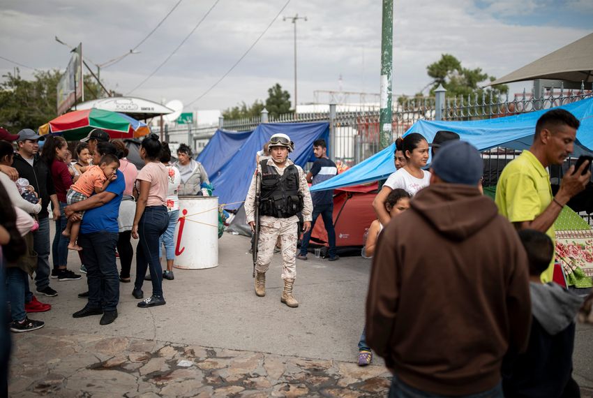 A Mexican soldier patrols a makeshift migrant camp at the base of Paso del Norte International Bridge in Ciudad Juarez.