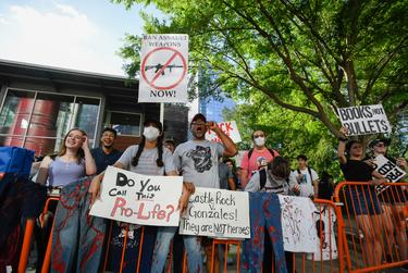 People protest the NRA Annual Meeting along Avenida de las Americas in front of George R. Brown Convention Center Friday, May 27, 2022, in Houston. (Justin Rex for The Texas Tribune)