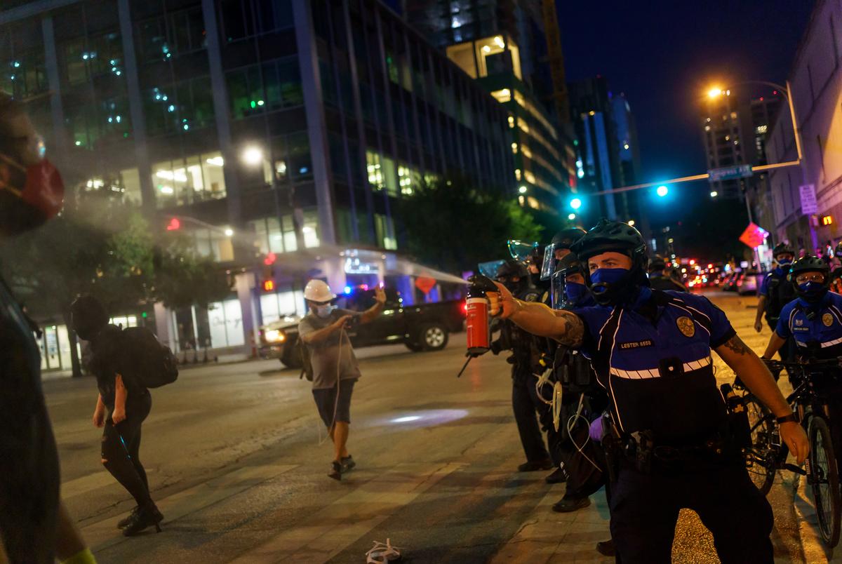 A police officer sprays a protester with pepper spray as protestors clashed with police in riot gear in downtown Austin on Aug. 1, 2020.