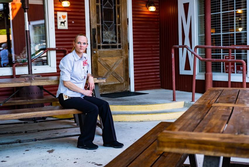 Donna Heath, floor manager of The Barn Door Restaurant, poses for a portrait during her shift in front of the restaurant in San Antonio on May 18, 2020.