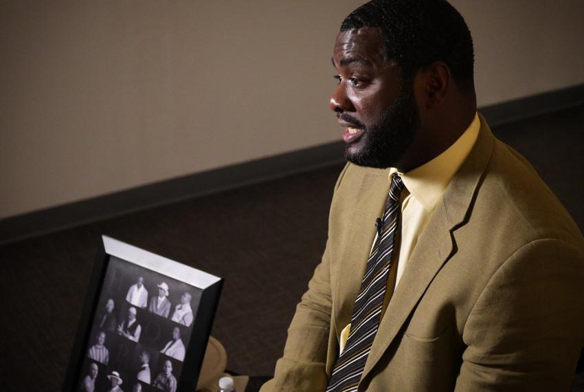 Christopher Scott, wrongfully convicted of murder, tells his story next to a photo of fellow exonerees in a Dallas office in July 2017. 