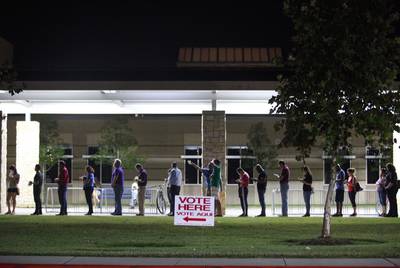 People wait to vote after polling places' official 7:00 closing time, at Tompkins High School in Katy in Fort Bend Co. on Nov. 6, 2018.