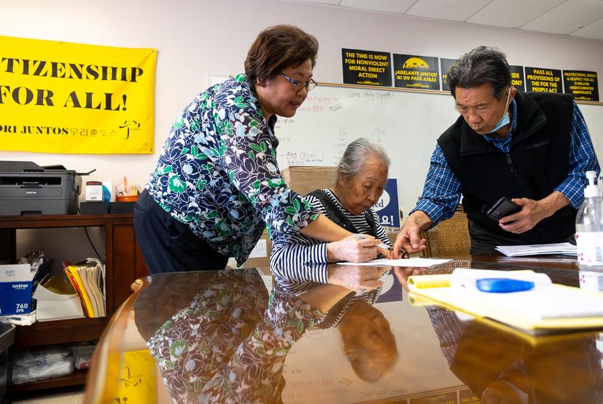 Woori Juntos Community Service Coordinator Terry S. Yun helps Hyun and Won Choi fill out paperwork at the Korean Community Center in the Spring Branch district of Houston, TX, on Thursday, Feb. 23, 2023.