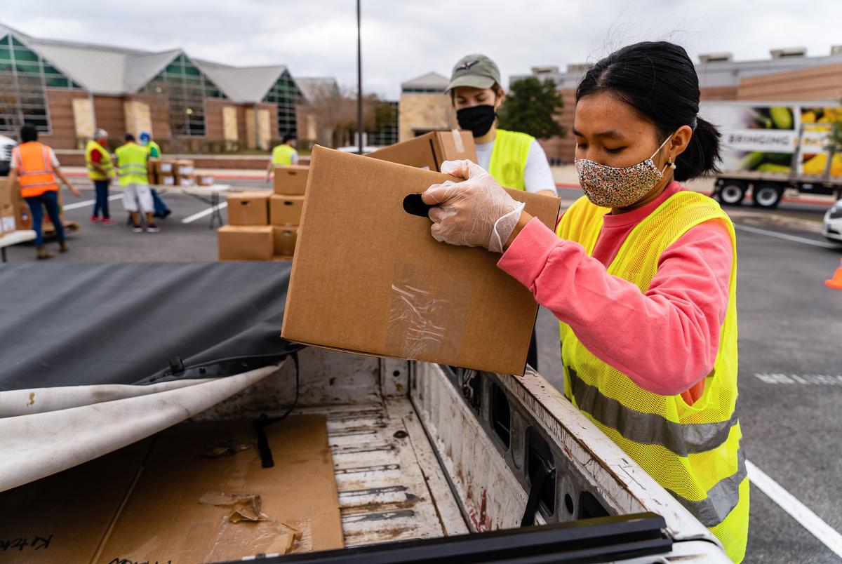 Tam Vo, right, a senior Biochemistry major at the University of Texas in Austin, loads a box of food into a truck. Vo is from Katy and does not own a car, but whenever she can get a ride to volunteer with the Central Texas Food Bank she is glad to do so. This is her fourth time volunteering.