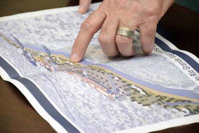 Laredo Mayor Pete Saenz points to features of the proposed River Vega project on a map.