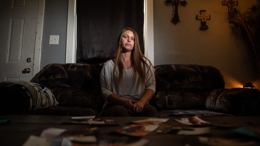 Amnisty sits in front of a table containing pictures of her son, at her home in Paris, Texas, on June 17, 2022. According to Amnisty, her son has suffered abuse while in the Texas Juvenile Justice Department system.