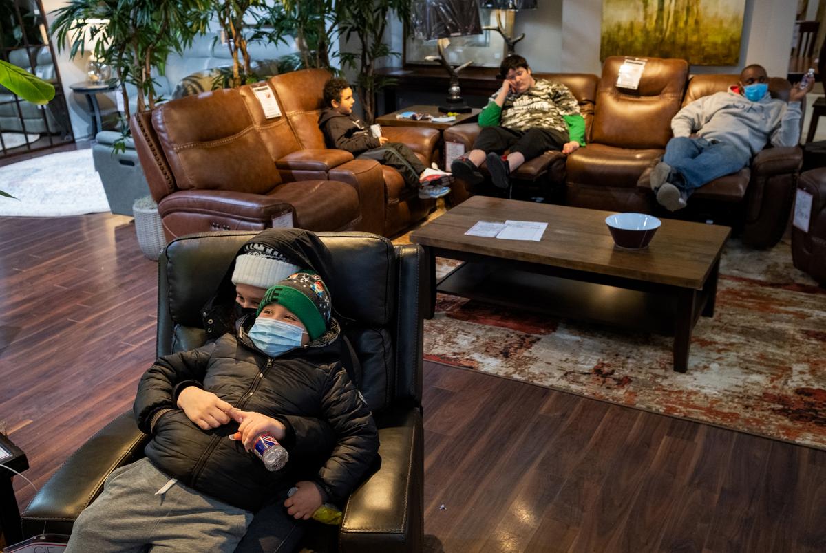 Nicole Colato, 12, holds her sibling Christian Colato, 8, at Gallery Furniture, which opened to the public as a warming center, on Feb. 16, 2021 in Houston. The snowfall on Feb. 15 continued to cause problems in Houston as well as other parts of Texas.