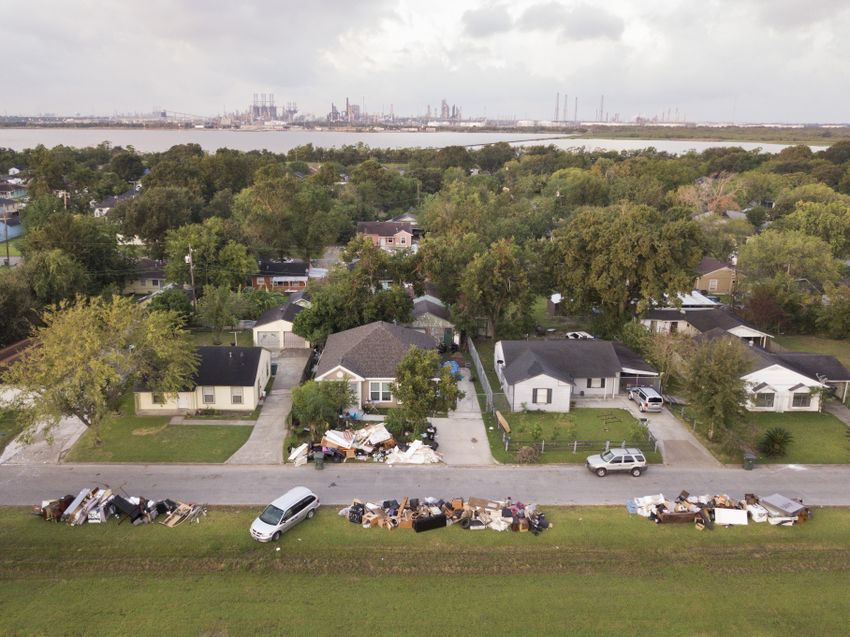 Motiva, the largest refinery inthe United States, in the distance in Port Arthur, Texas Wednesday, September 20, 2017 where piles of flood damaged debris are piled outside of homes. (Photo by Michael Stravato)